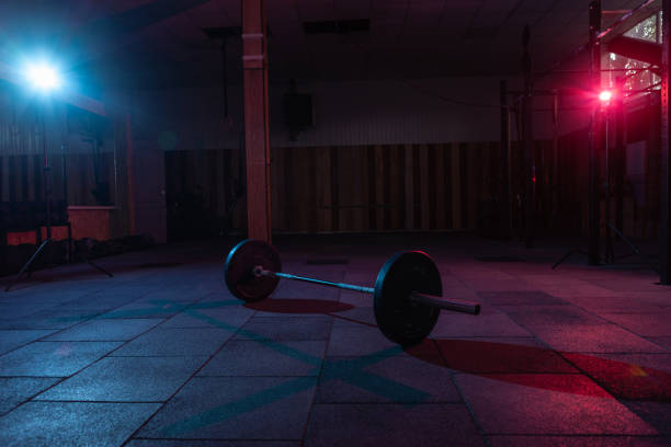 istock Barbell in a dark grungy gym with blue red neon light 1313692939