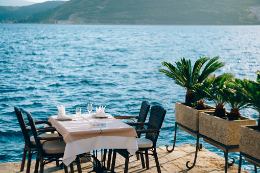 Reserved table in a restaurant by the sea, near the water. High quality photo