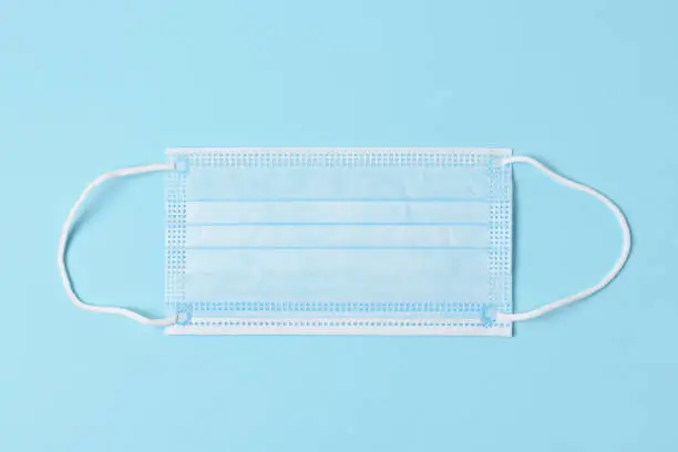 Blue Surgical Mask on a Blue Background, High angle view.
