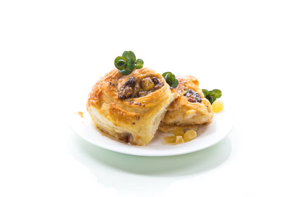 Sweet curled bun with jam, raisins in powdered sugar on a plate