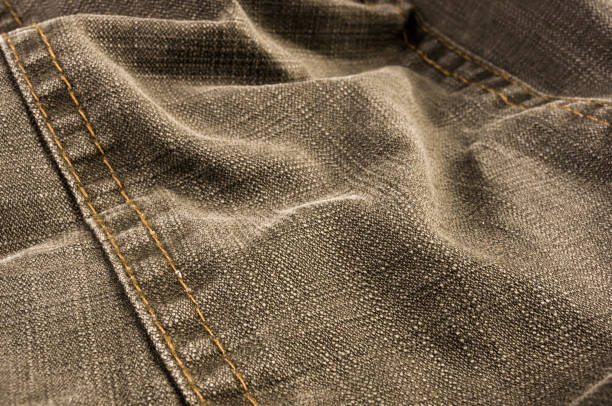 istock clothing items stonewashed cotton fabric texture with seams, clasps, buttons and rivets, macro 1313702895