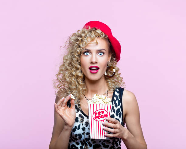 istock Pretty woman in 80's style clothes holding popcorn box 1313703120