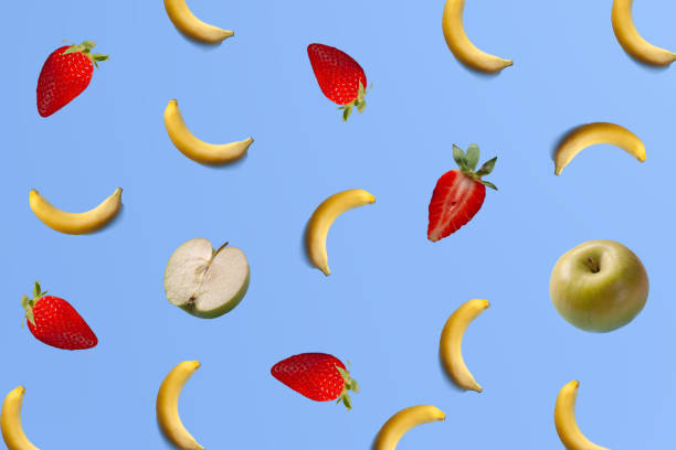 istock Pattern made with fresh bananas, apples and strawberries fruit on bright light blue background 1313706620