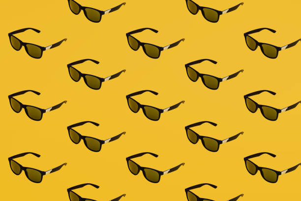 Black sunglasses patter on yellow background. Summer concept
