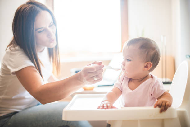 istock Mother feed her little daughter with a spoon 1313709981