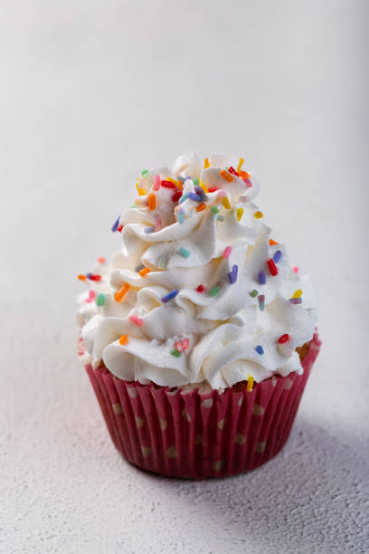 istock Tasty party cupcakes on the table. Cupcakes with whipped cream. 1313710018