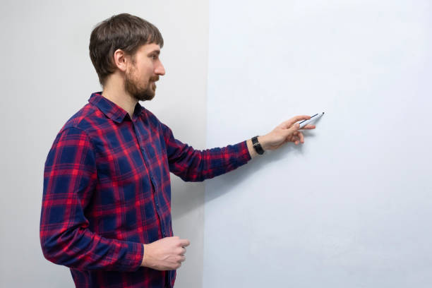 istock Young man writing on a white board in the office. Man makes a presentation. Trainings, education, startup. Business startup and entrepreneurship concept 1313711417