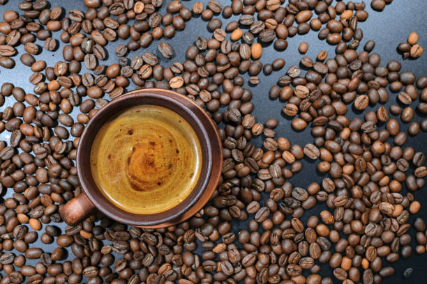 istock A cup of coffee on coffee beans on the table. Top view. 1313712702