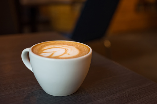 Cup of hot coffee on a wooden table.