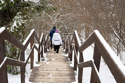 A family of tourists on a hiking trail in the mountains covered in snow on the mountainside. Selective focus. Tustan. Carpathians. Ukraine