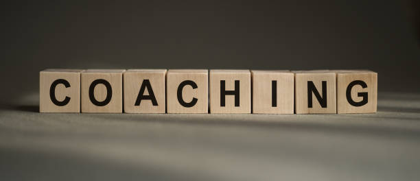 istock A wooden blocks with the word coaching written on it on a gray background. 1313719467