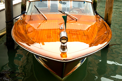 beautiful old shiny wooden motorboat parked on the canals of Venice