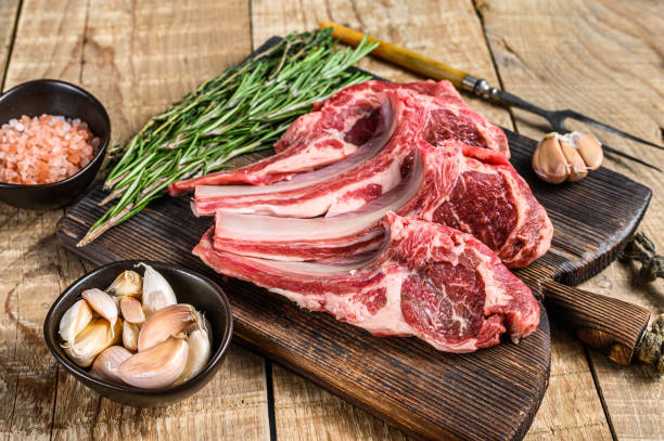 Lamb raw cutlets chops  with salt, pepper and garlic. wooden background. Top view Lamb raw cutlets chops  with salt, pepper and garlic. wooden background. Top view. rack of lamb stock pictures, royalty-free photos & images