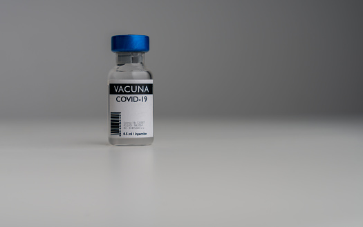 Close-up on a COVID-19 vaccine ampoule with label in Spanish â vaccination program concepts