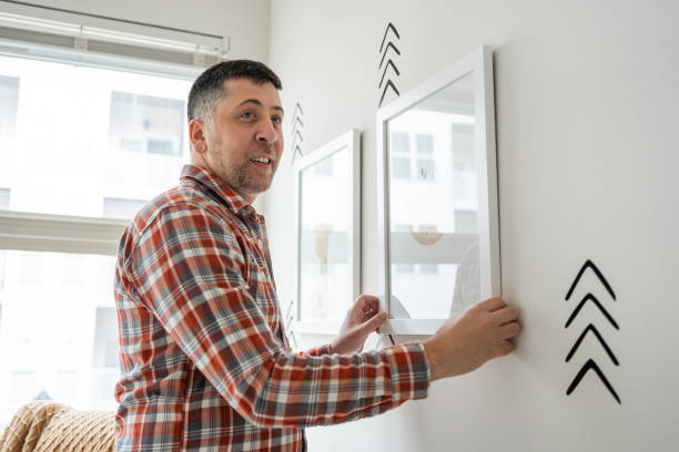 istock Father hanging frames in the nursery room 1313721110