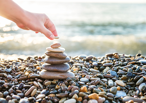 Detail of person stacking rocks.People life balance concept