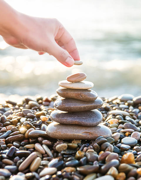 istock human hand put last stone at the pyramid 1313723386