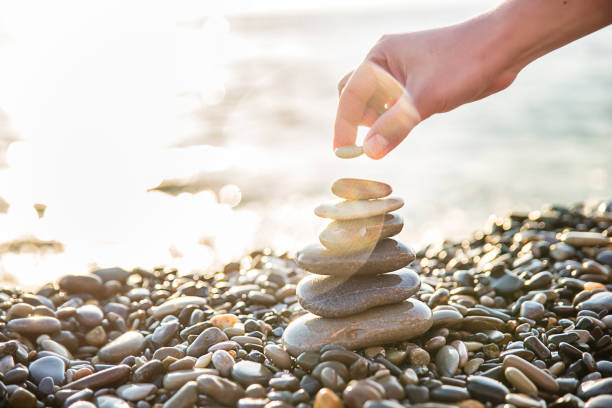 istock human hand put last stone at the pyramid 1313723396