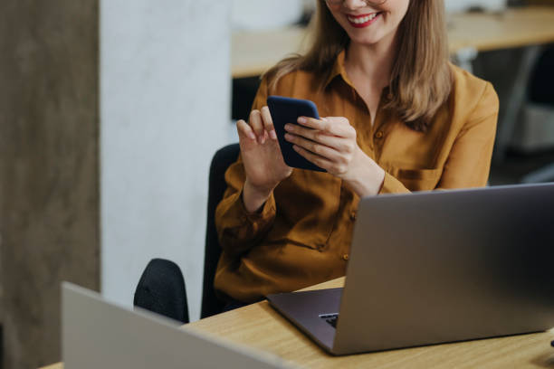 istock Distraction at Work: Unrecognizable Blonde Businesswoman Using her Mobile Phone while Sitting at the Office 1313726636