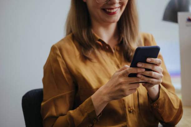 istock Distraction at Work: Unrecognizable Blonde Businesswoman Using her Mobile Phone while Sitting at the Office 1313726638