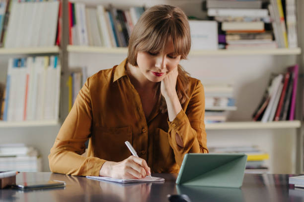 istock Hardworking Blonde Businesswoman Taking Notes at Work 1313726683
