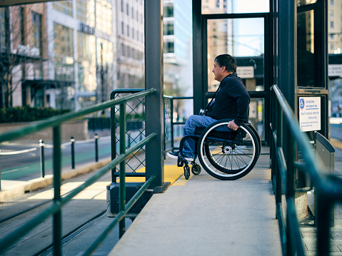 A disabled man, using a ramp with his wheelchair.