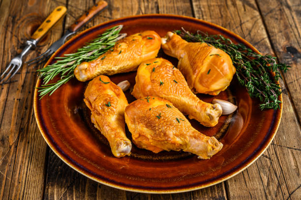 istock Fresh Smoked chicken drumsticks on a rustic plate with herbs. wooden background. Top view 1313730226