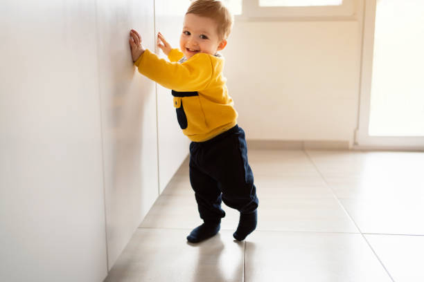 istock Smiling baby boy making his first steps at home 1313733569