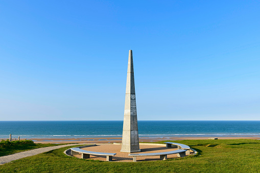 This landscape photo was taken in France, normandy, Calvados, on the edge of the English Channel, in the spring. We see the monument of the WN62 support point on the beach of Omaha beach during a day under the Sun.