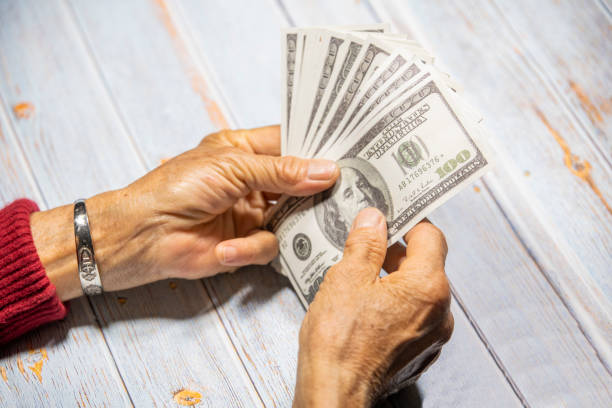 istock The old man's hand is counting money 1313735283