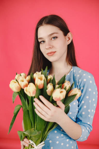 istock Girl with flowers on a red background 1313735578