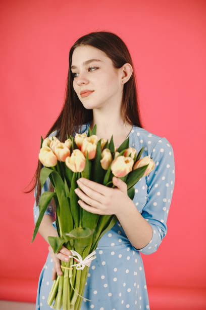 istock Girl with flowers on a red background 1313735584