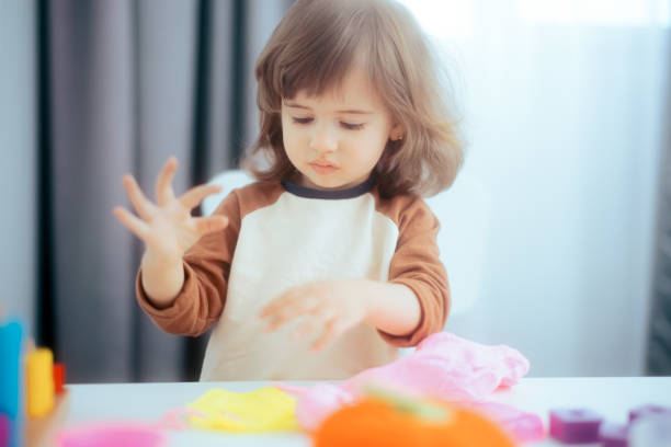 istock Happy Child Sitting at the Table Playing with Plasticine 1313739957