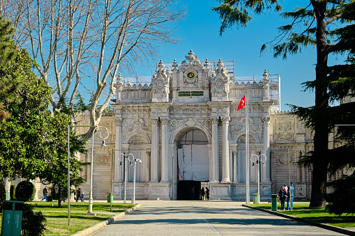04.03.2021. Turkey istanbul. dolmabahce palace established by Ottoman empire and magnificent entrance gate of ottoman stool covered and made of marble materials with Turkish flag.