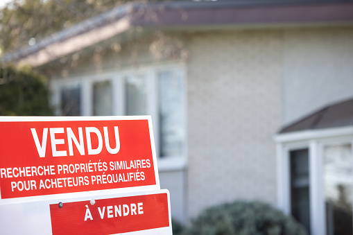 House Sold Sign in the Suburb (French Language : Vendu)