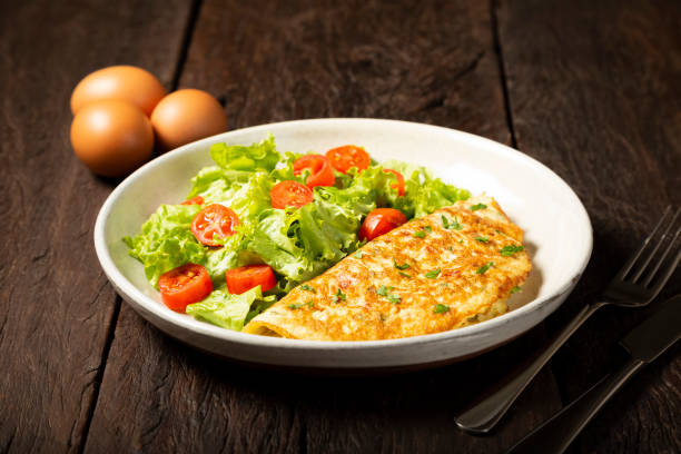 istock Omelet with cheese and lettuce and tomato salad. 1313742627