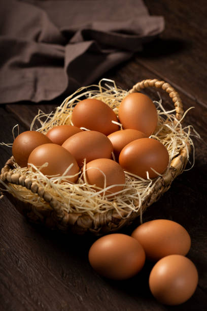 istock Basket with brown chicken eggs goes up the table. 1313744173
