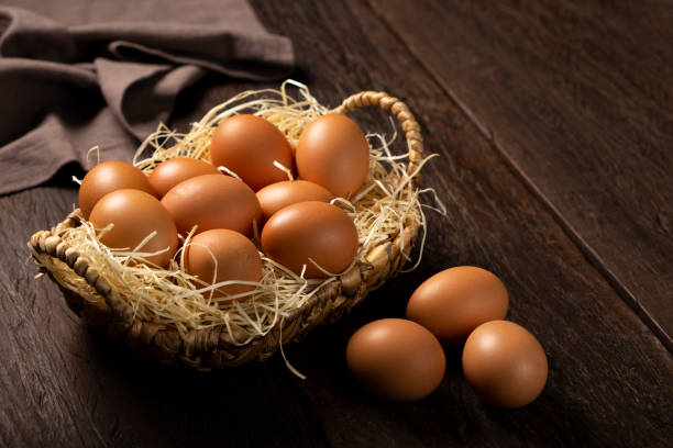 istock Basket with brown chicken eggs goes up the table. 1313744184