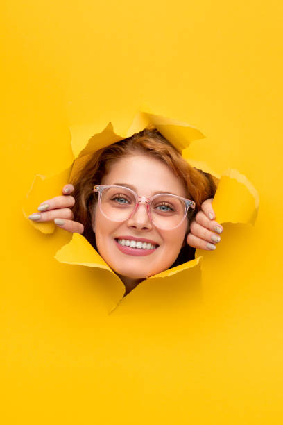 istock Smiling female looking through torn poster 1313744328