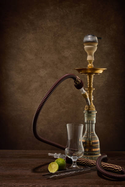 istock Hookah (shisha) and empty glass for cocktail with lime on dark background. Weekend or holiday party 1313747249