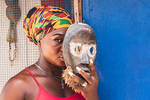 African woman with an old wooden mask in her hand