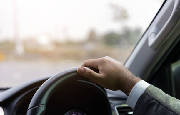 istock Young man driving car on the road. Car steering wheel handle. 1313758865