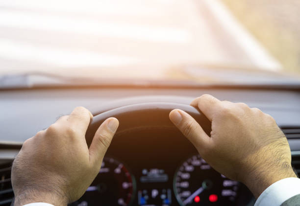 istock Young man driving car on the road. Car steering wheel handle. 1313758900