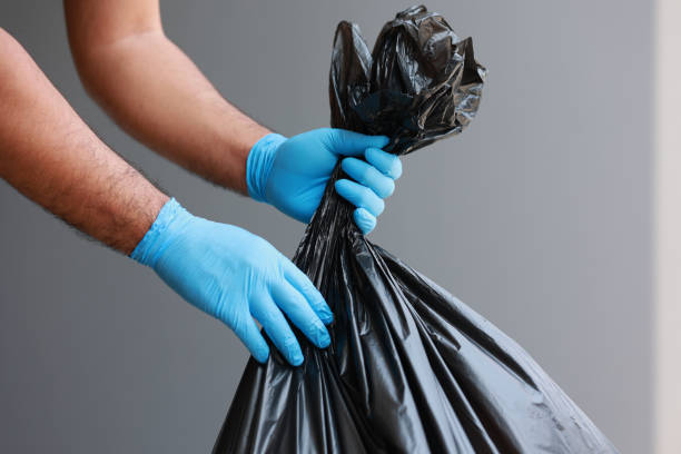 el joven separó los desechos peligrosos en una bolsa negra grande y lo puso en la basura. la correcta clasificación de residuos - garbage bag fotografías e imágenes de stock