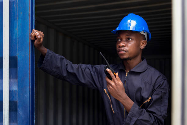 istock black african amarican man worker working control loading freight containers at commercial shipping dock. cargo freight dock and import export logistic concept. 1313765150