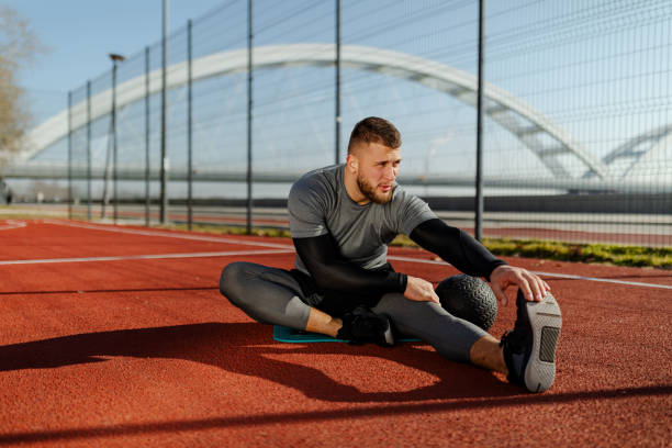 istock Young athletic runner doing stretching exercise, preparing for morning workout near river. 1313765993