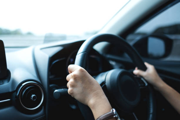 istock a woman holding steering wheel while driving a car 1313768191