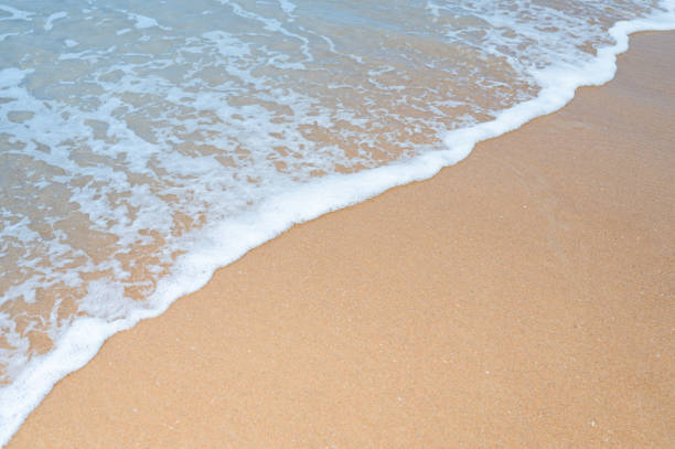 mousse d’onde de mer sur la plage de sable brun en saison d’été, thaïlande - sandy brown bay beach sand photos et images de collection