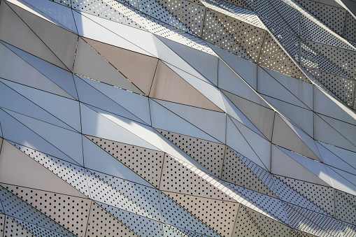 a futuristic architectural style facade concept design wavy and diamond pattern with  aluminum composite panels or cladding with perforated sheets on modern building, Abstract background .