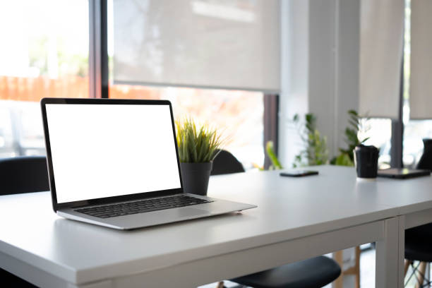 istock Computer laptop with empty screen on white table in modern meeting room. 1313772876